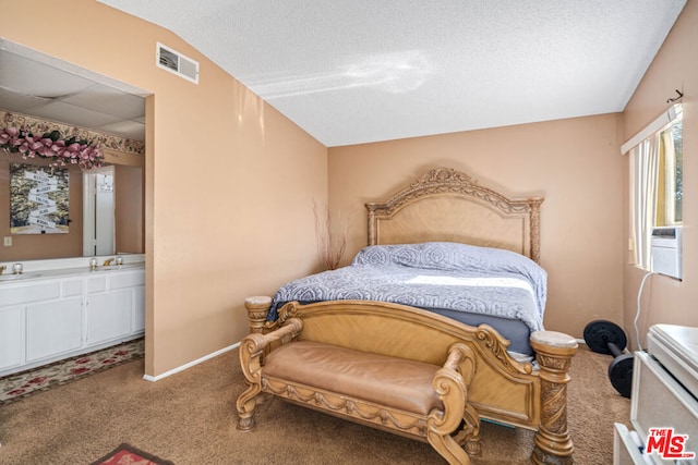 bedroom with a textured ceiling, carpet floors, lofted ceiling, and sink