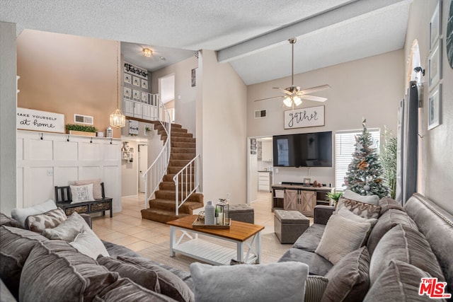 tiled living room featuring a textured ceiling, lofted ceiling with beams, and ceiling fan