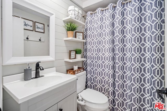 bathroom featuring a shower with curtain, wood walls, vanity, and toilet