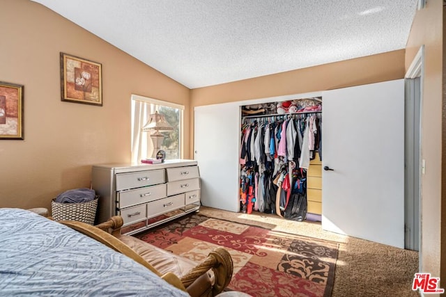 bedroom with vaulted ceiling, carpet floors, a textured ceiling, and a closet