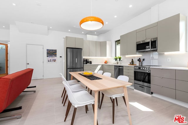 kitchen with gray cabinetry, light tile patterned floors, and stainless steel appliances