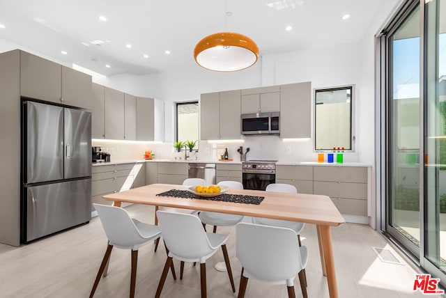 kitchen with gray cabinetry, backsplash, sink, and appliances with stainless steel finishes