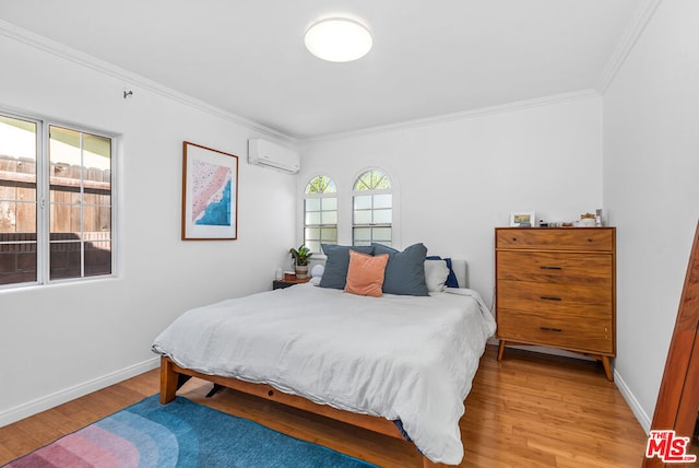 bedroom featuring hardwood / wood-style flooring, ornamental molding, and a wall unit AC