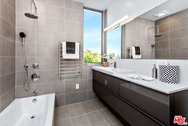 bathroom featuring tile patterned floors, vanity, radiator heating unit, and tiled shower / bath combo