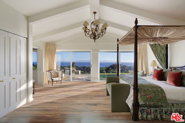 bedroom with a mountain view, lofted ceiling with beams, hardwood / wood-style flooring, a chandelier, and a closet