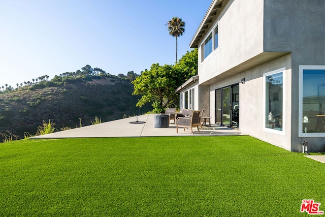 view of yard with outdoor lounge area, a mountain view, and a patio