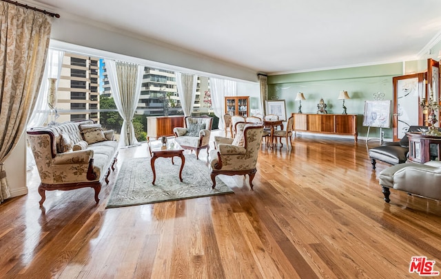 living room with wood-type flooring and ornamental molding