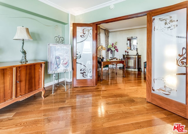 foyer entrance featuring crown molding, french doors, and light wood-type flooring