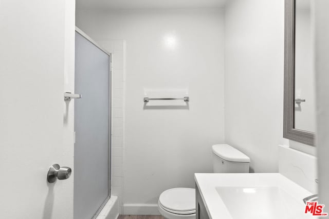 bathroom with vanity, an enclosed shower, and toilet