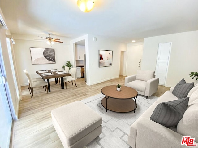 living room featuring ceiling fan and light hardwood / wood-style floors