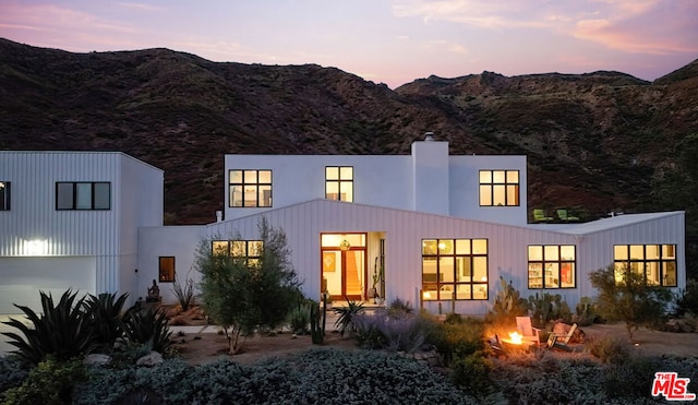 back house at dusk with a mountain view