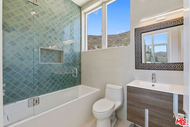 full bathroom featuring a mountain view, vanity, toilet, and a healthy amount of sunlight