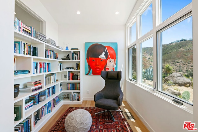 living area featuring a wealth of natural light and hardwood / wood-style flooring