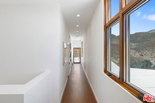 hallway with plenty of natural light and hardwood / wood-style flooring