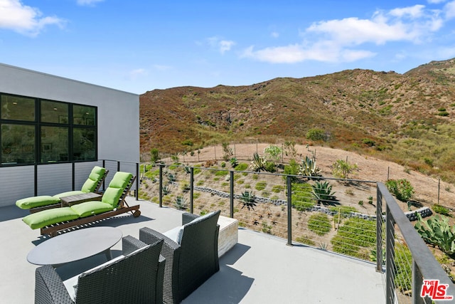 view of patio / terrace with a mountain view and a balcony