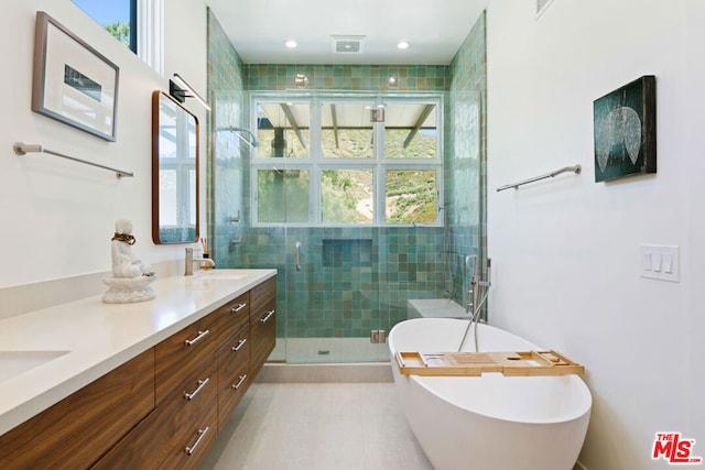 bathroom with shower with separate bathtub, vanity, and tile patterned floors