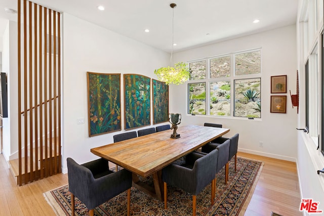 dining area with light hardwood / wood-style flooring and a chandelier