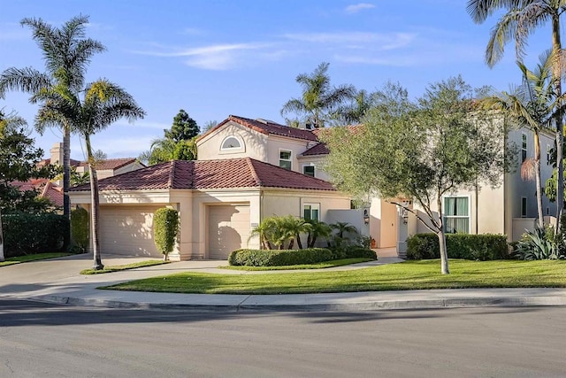 mediterranean / spanish-style house featuring a front yard and a garage