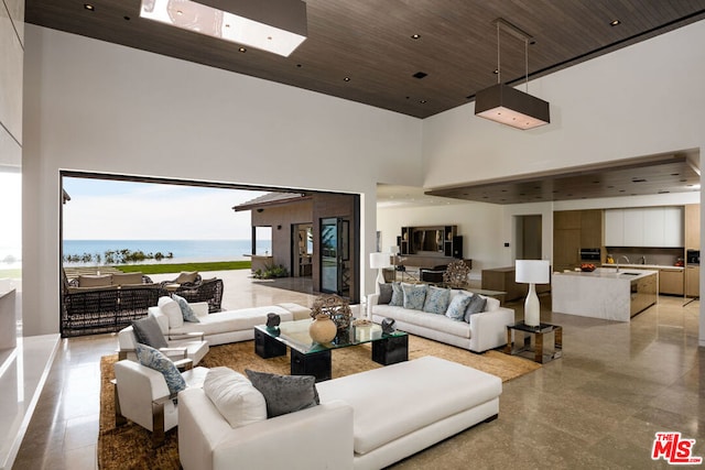 living room with sink, a water view, wood ceiling, and a high ceiling