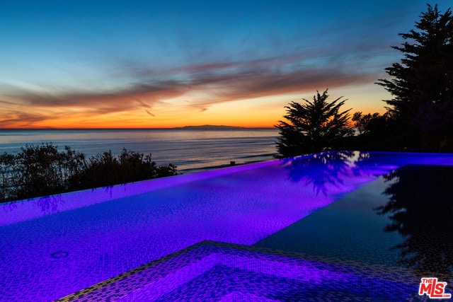 pool at dusk with a water view