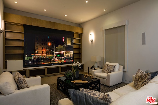 cinema room with built in shelves and dark hardwood / wood-style flooring