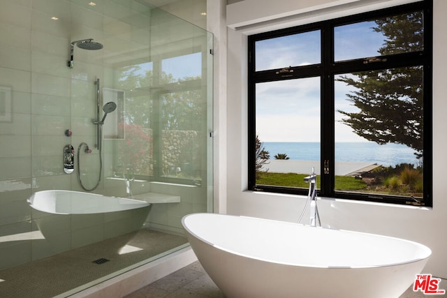 bathroom featuring plus walk in shower and a water view