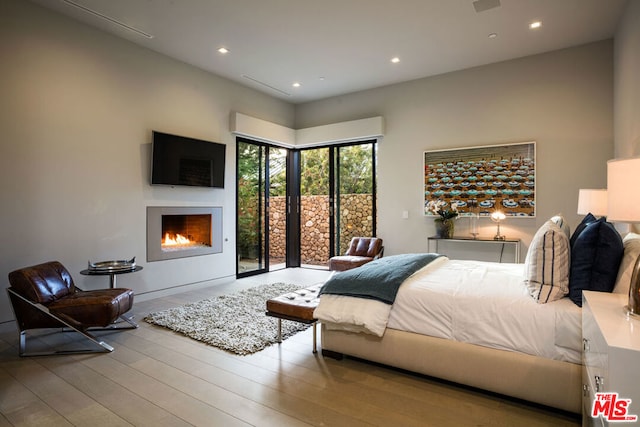 bedroom with access to outside and light hardwood / wood-style flooring