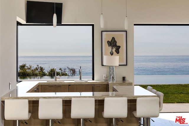 dining area featuring a water view, a wealth of natural light, and sink