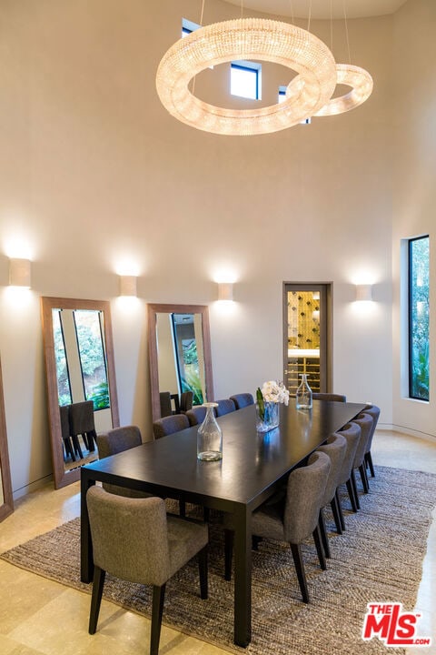 dining space featuring a high ceiling and an inviting chandelier