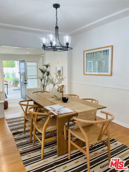 dining space featuring hardwood / wood-style floors and a chandelier