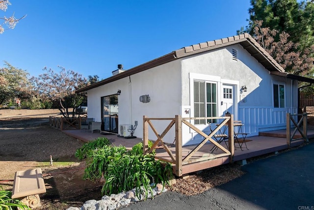 back of house featuring ac unit and a wooden deck