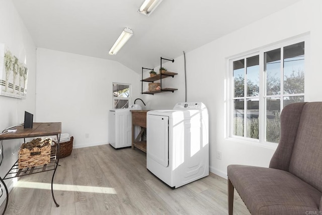 laundry area with plenty of natural light, light wood-type flooring, and washer / clothes dryer