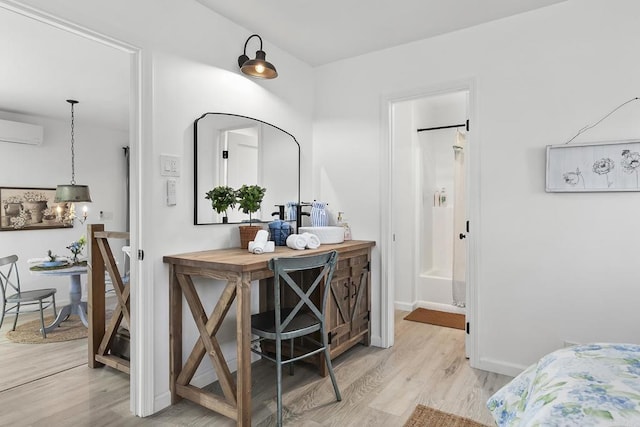 interior space with butcher block countertops, a wall mounted AC, light hardwood / wood-style flooring, and decorative light fixtures