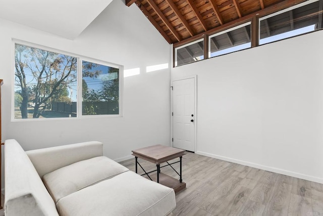 living area with beam ceiling, light wood-type flooring, high vaulted ceiling, and wooden ceiling