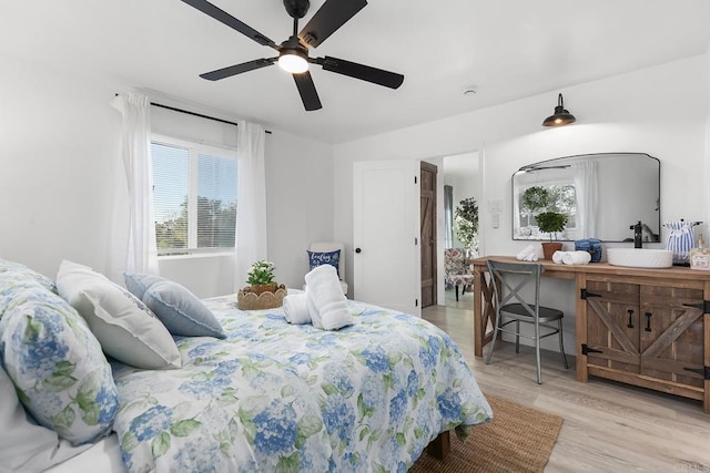 bedroom with light hardwood / wood-style floors and ceiling fan