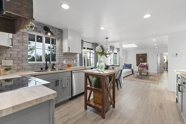 kitchen featuring stainless steel dishwasher, gray cabinetry, sink, pendant lighting, and white cabinetry