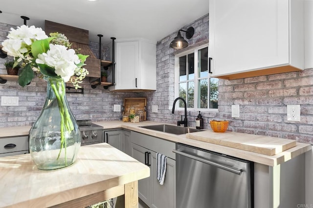 kitchen with gray cabinetry, white cabinets, sink, stainless steel dishwasher, and decorative light fixtures