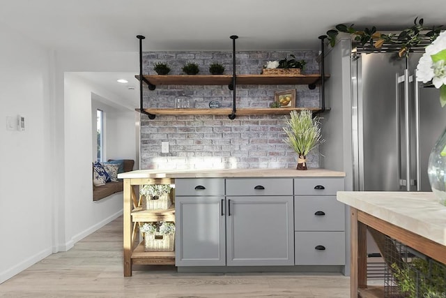 bar with decorative light fixtures, light hardwood / wood-style flooring, and gray cabinetry