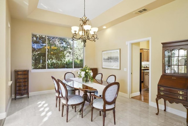 dining space featuring a notable chandelier, visible vents, a tray ceiling, and baseboards