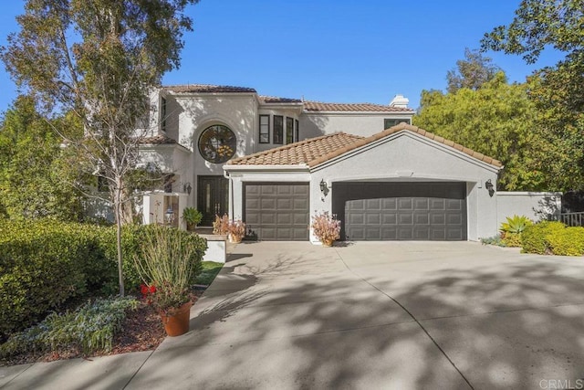 mediterranean / spanish house with concrete driveway, a tiled roof, an attached garage, and stucco siding