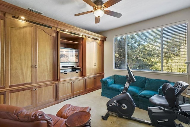 living area with visible vents, light colored carpet, and a ceiling fan