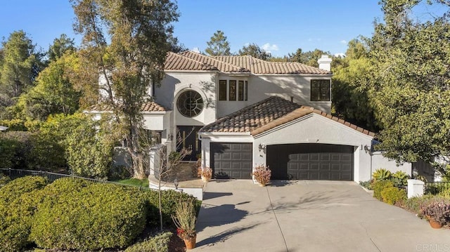 mediterranean / spanish-style house with a tile roof, a garage, and driveway