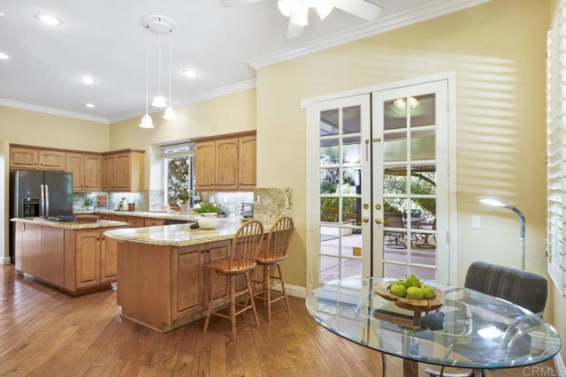 kitchen featuring refrigerator with ice dispenser, light wood-type flooring, backsplash, and ornamental molding