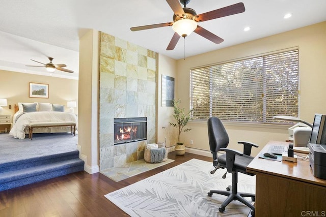 office space featuring recessed lighting, a fireplace, dark wood-style flooring, and baseboards