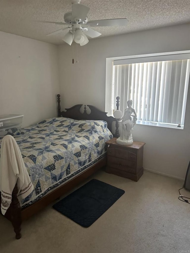 carpeted bedroom with ceiling fan and a textured ceiling