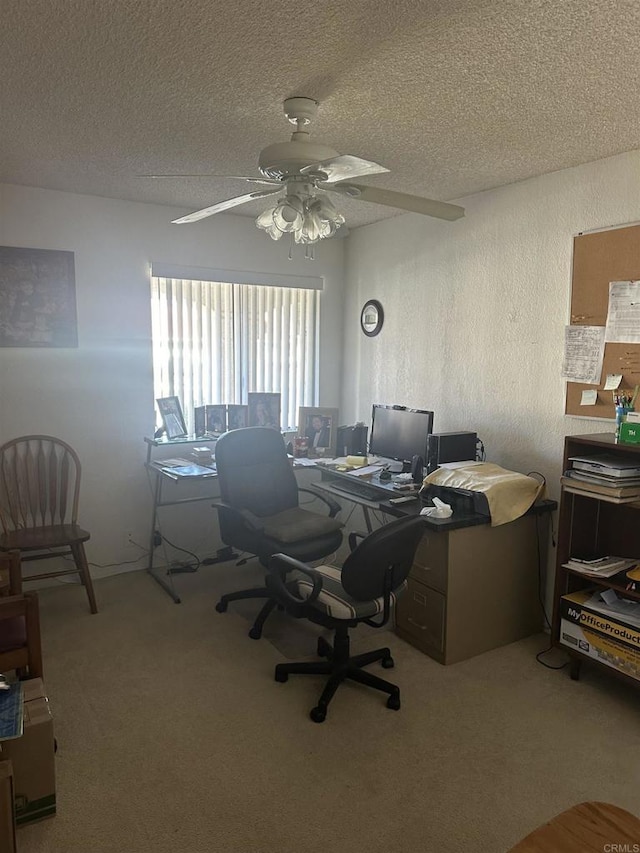 carpeted office space featuring ceiling fan and a textured ceiling