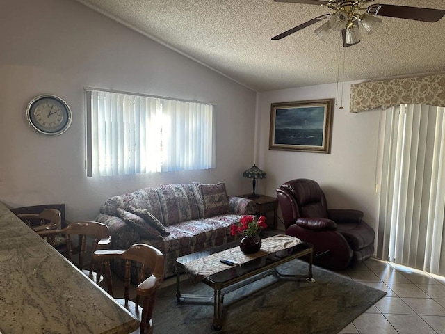 tiled living room with a textured ceiling, ceiling fan, and lofted ceiling