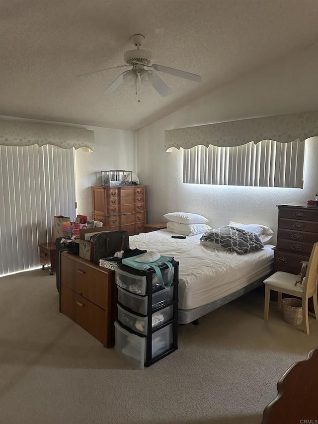 bedroom with a textured ceiling, ceiling fan, carpet, and lofted ceiling