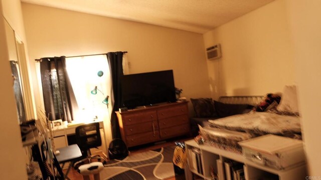 bedroom with vaulted ceiling and an AC wall unit