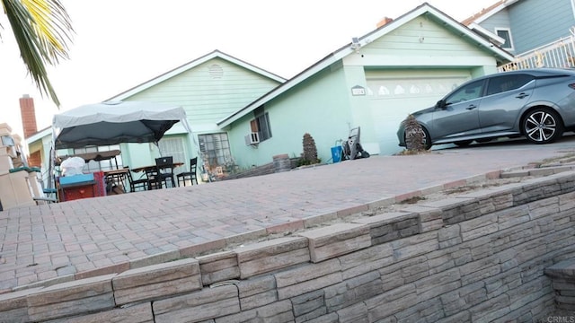 rear view of property with an attached garage and outdoor dining area